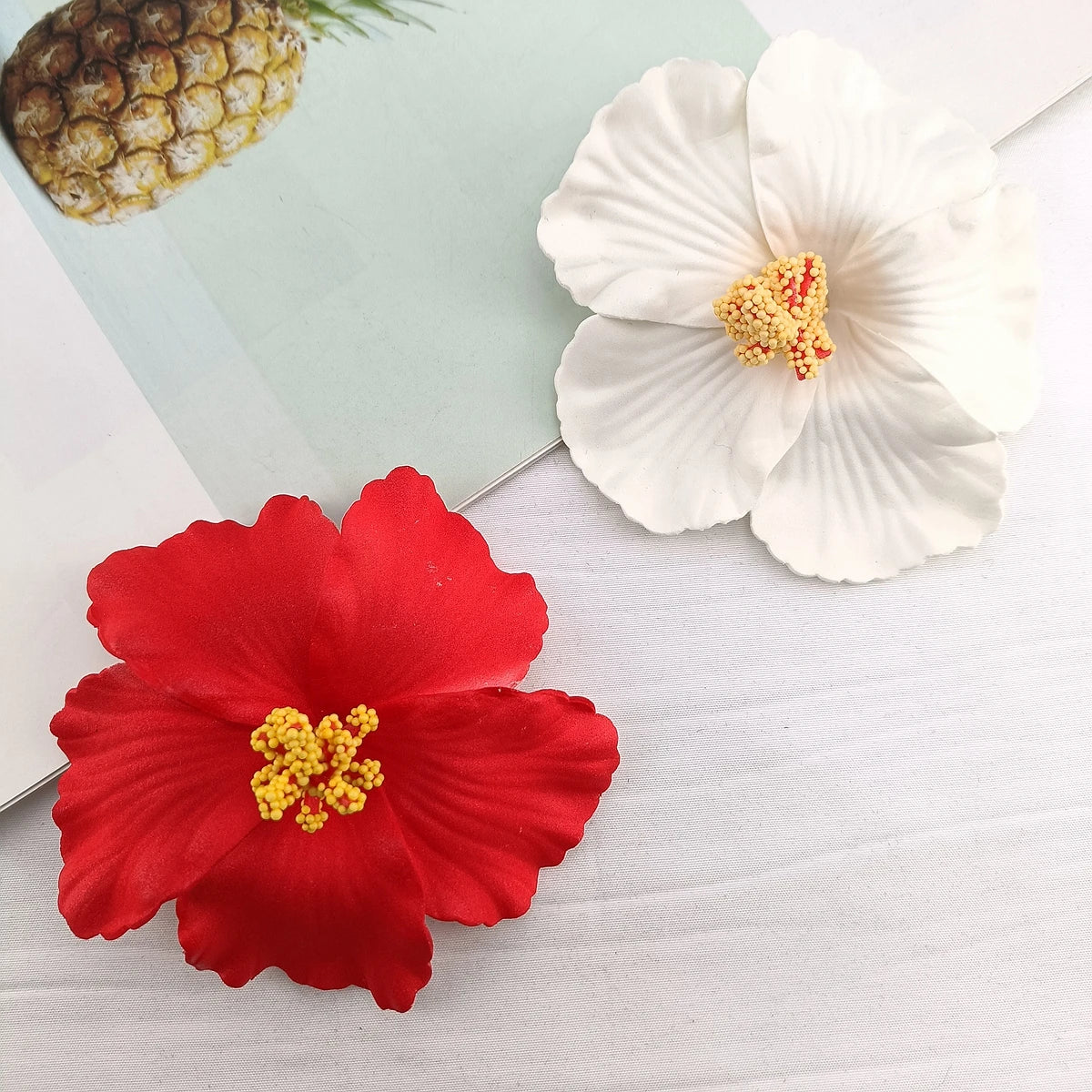 A set of delicate floral hair clips featuring white and red flowers on a light background.