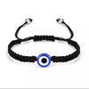 Black braided evil eye charm bracelet with a blue and white circular bead.