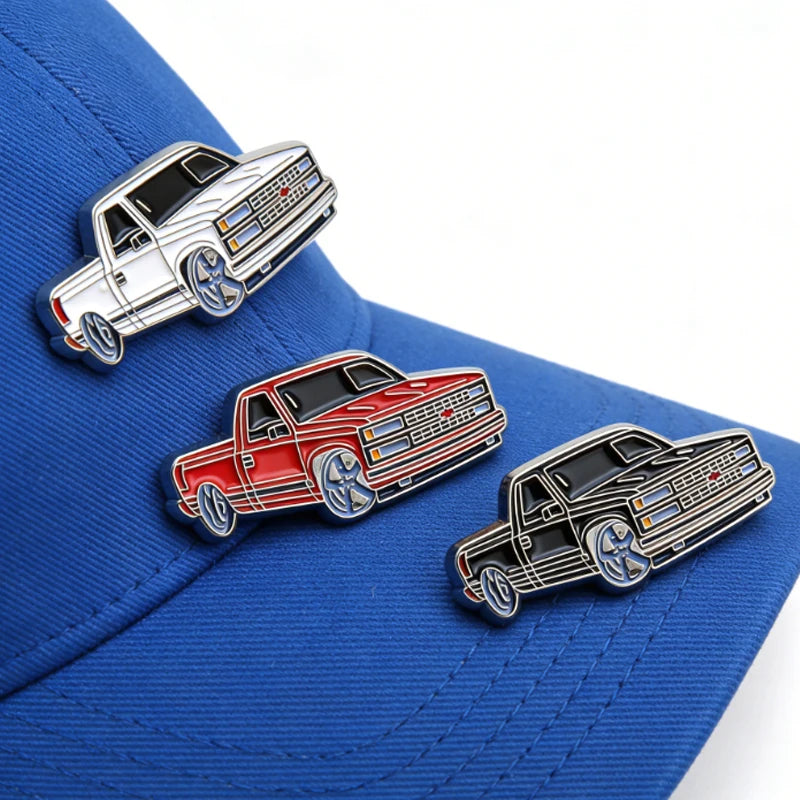 A metal clip pin featuring a red and silver retro Mexico style vehicle design on a blue baseball cap.
