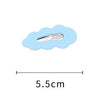 A silver adjustable hair tie is shown against a light blue, cloud-shaped background.