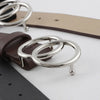 Nahaufnahme eines Damen-Doppelrings aus PU-Leder mit silbernen Ringen und braunem Lederriemen.