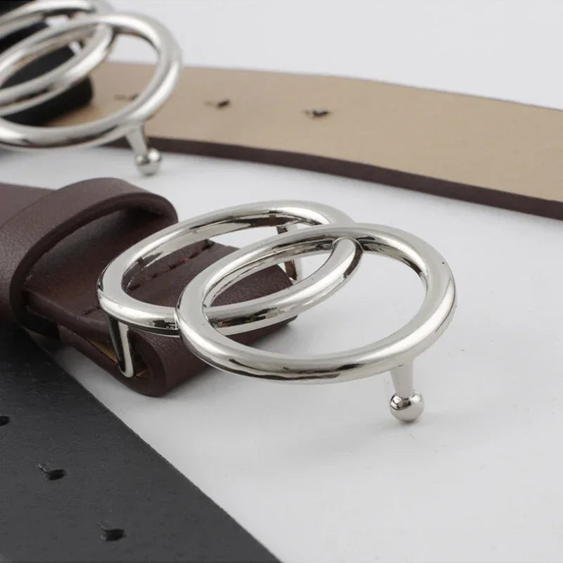 Nahaufnahme eines Damen-Doppelrings aus PU-Leder mit silbernen Ringen und braunem Lederriemen.