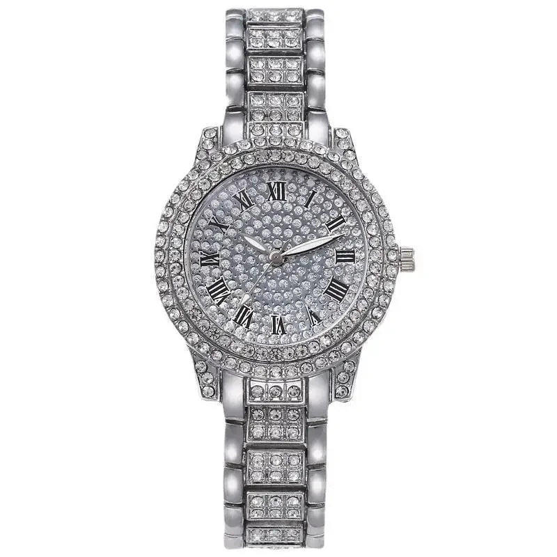 A silver-toned quartz watch with a crystal face and rhinestone accents on the band.