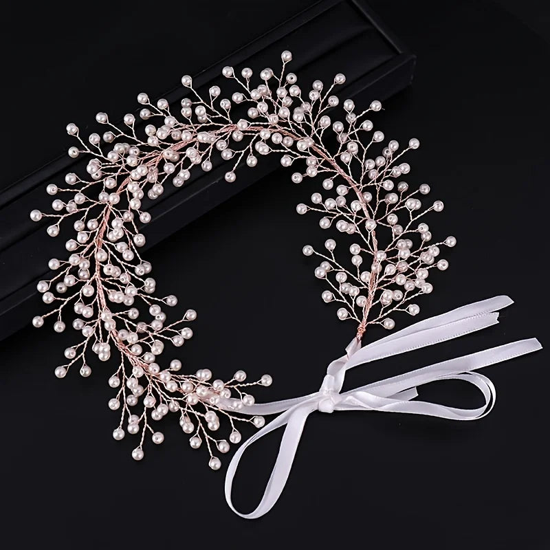 A delicate pink pearl hair vine wreath with a white ribbon bow.