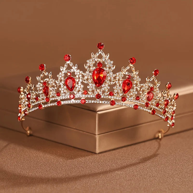 Diadema de tiara barroca cristalina roja brillante y clara para accesorios de peinado nupcial, sobre una caja neutra.