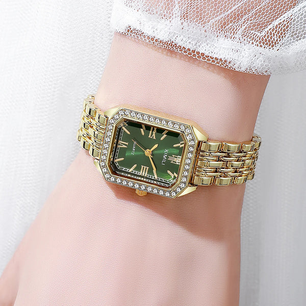 A gold-toned quartz wristwatch with a square face and rhinestone accents worn on a wrist.
