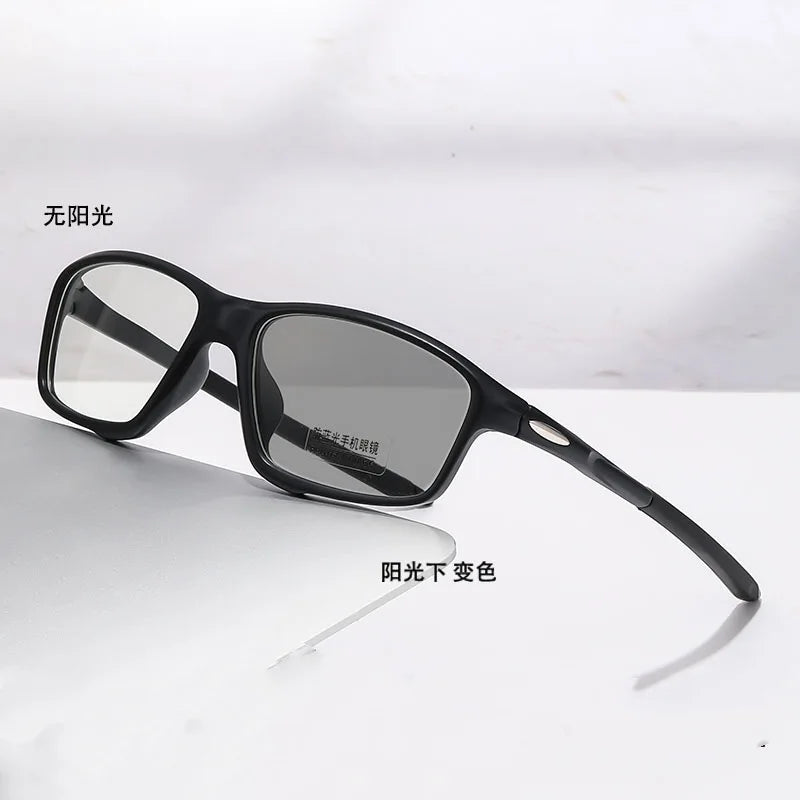 A pair of black photochromic reading glasses resting on a white surface.