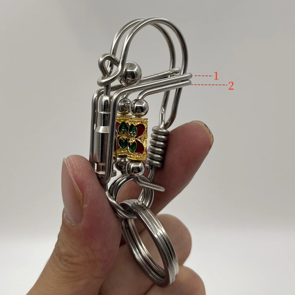 Une clé mécanique en acier inoxydable avec un élément décoratif de couleur or est tenue dans une main.