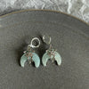 Silver stainless steel hoop earrings featuring celestial designs and pale green moonstone-like stones