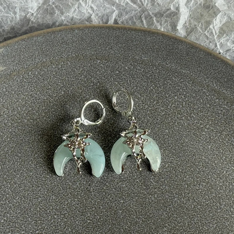 Silver stainless steel hoop earrings featuring celestial designs and pale green moonstone-like stones