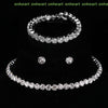 A set of four crystal jewelry pieces including a ring, bracelet, and earrings displayed on a black background.