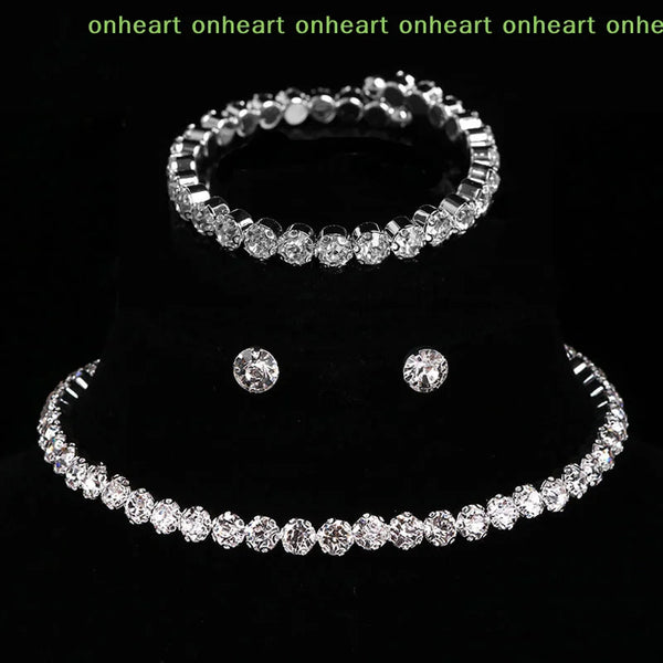 A set of four crystal jewelry pieces including a ring, bracelet, and earrings displayed on a black background.