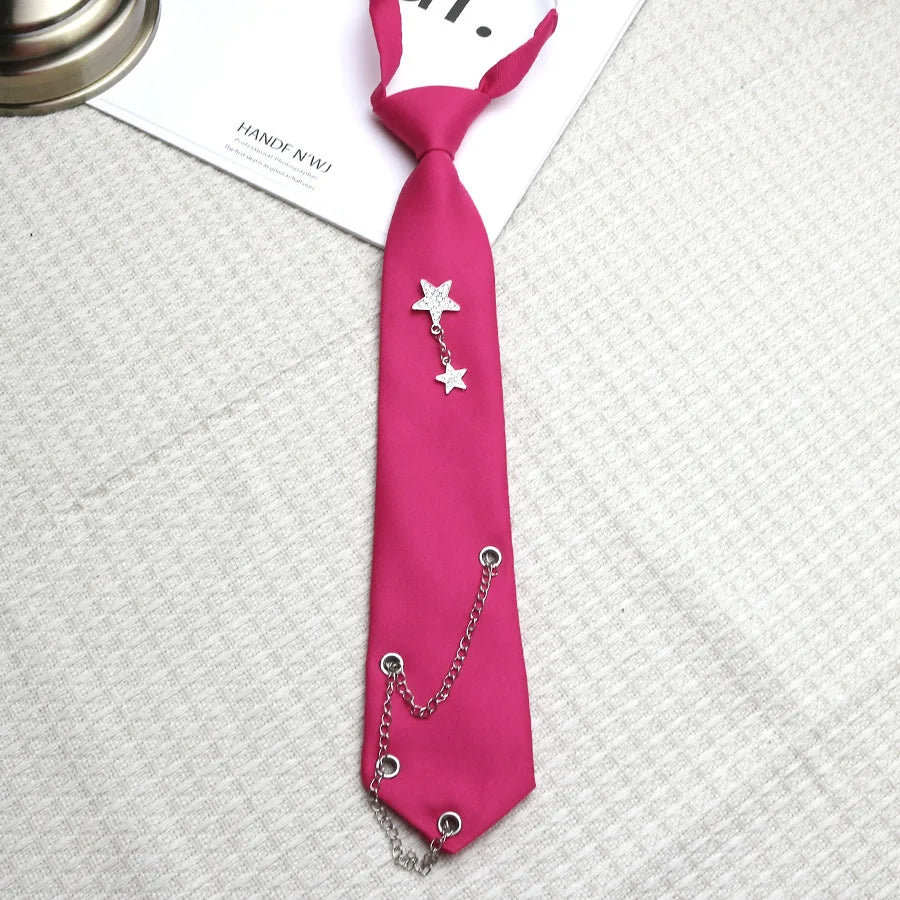 A pink satin tie with a silver chain star pendant and a matching chain attached.