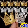 A collection of gold and silver mini crown cake toppers for parties shown on a hand.