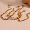 Gold chain bracelet with round water drop zircon charms laid on a beige surface.