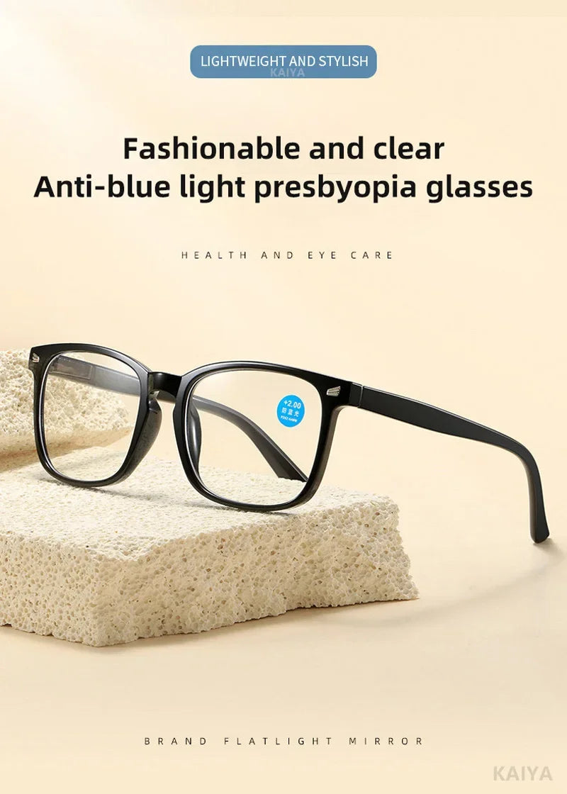 Un par de gafas presbiónicas negras anti-luz azul sobre una superficie blanca texturizada.