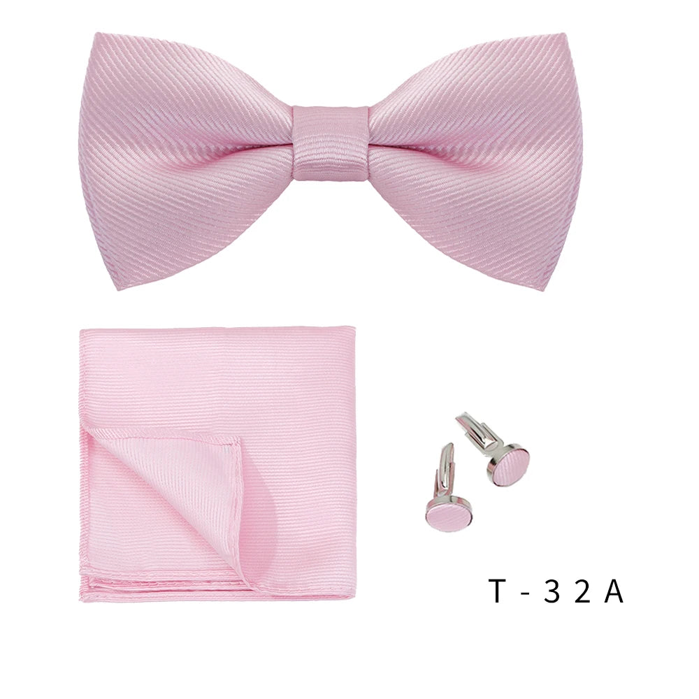 A pink striped bow tie and a folded pink handkerchief are shown with a pair of silver cufflinks.