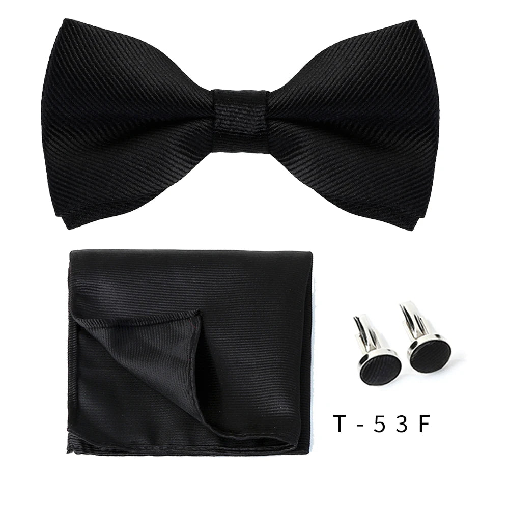 Black bow tie and cufflinks set displayed on a white background.