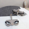 A light gray pouch designed to hold and store a pair of eyeglasses, shown next to a similar-shaped leather accessory.