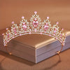 Diadema de cristal rosa brillante y transparente con detalles florales, mostrada en una caja de luz.