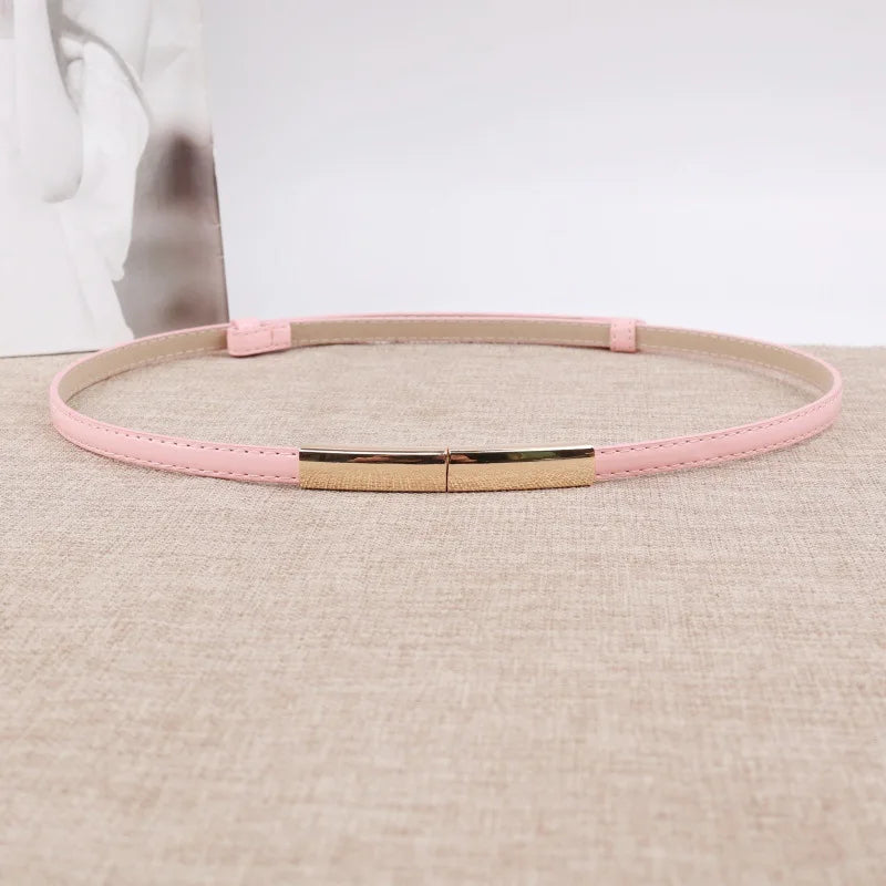 Pinkes Leder-Slim-Gurt mit goldener Schnalle auf beigem Stoff