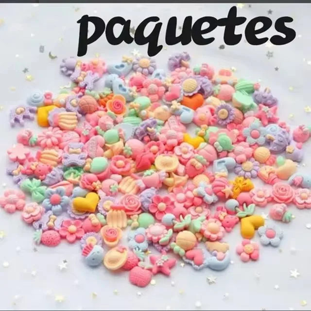 A pile of colorful resin nail art charms and embellishments scattered on a white surface.