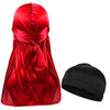 Pañuelo turbante de seda roja vibrante para hombre junto a un gorro negro.