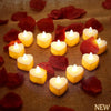 A collection of 24 heart-shaped LED flameless tealight candles arranged on a brown fabric with red rose petals.