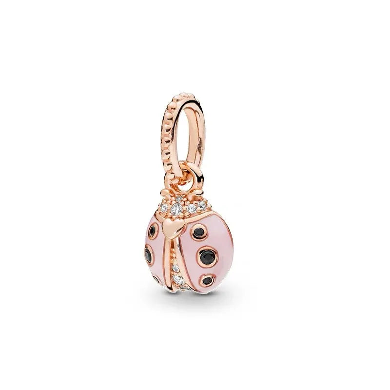 Rose gold cherry blossom charm pendant with a textured bail and a round, pink, spotted charm.