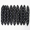 A set of ten black hair curling rollers with white polka dots arranged in a row.