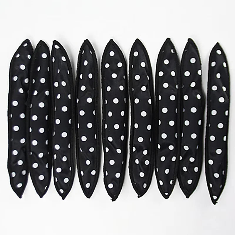 A set of ten black hair curling rollers with white polka dots arranged in a row.