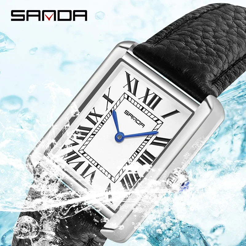 Eine silberne Uhr mit blauem Zifferblatt und Lederarmband spritzt im Wasser.
