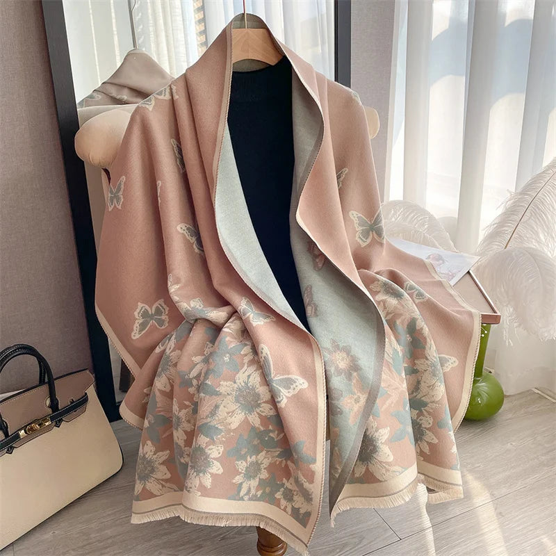 A soft pink and beige plaid cashmere feel scarf and shawl wrap draped on a hanger.
