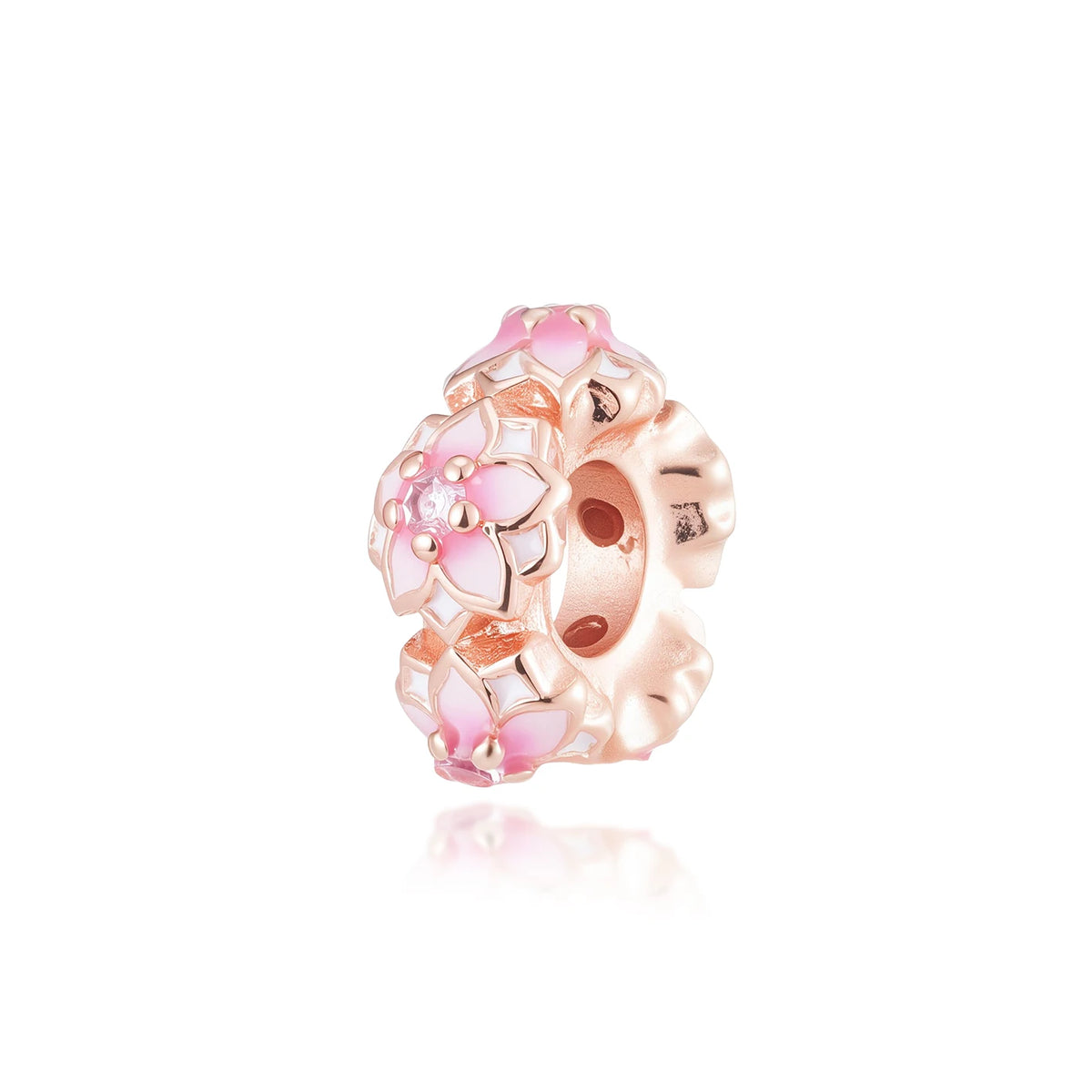 Primer plano de un dije de color oro rosa con diseños florales rosa y blanco.