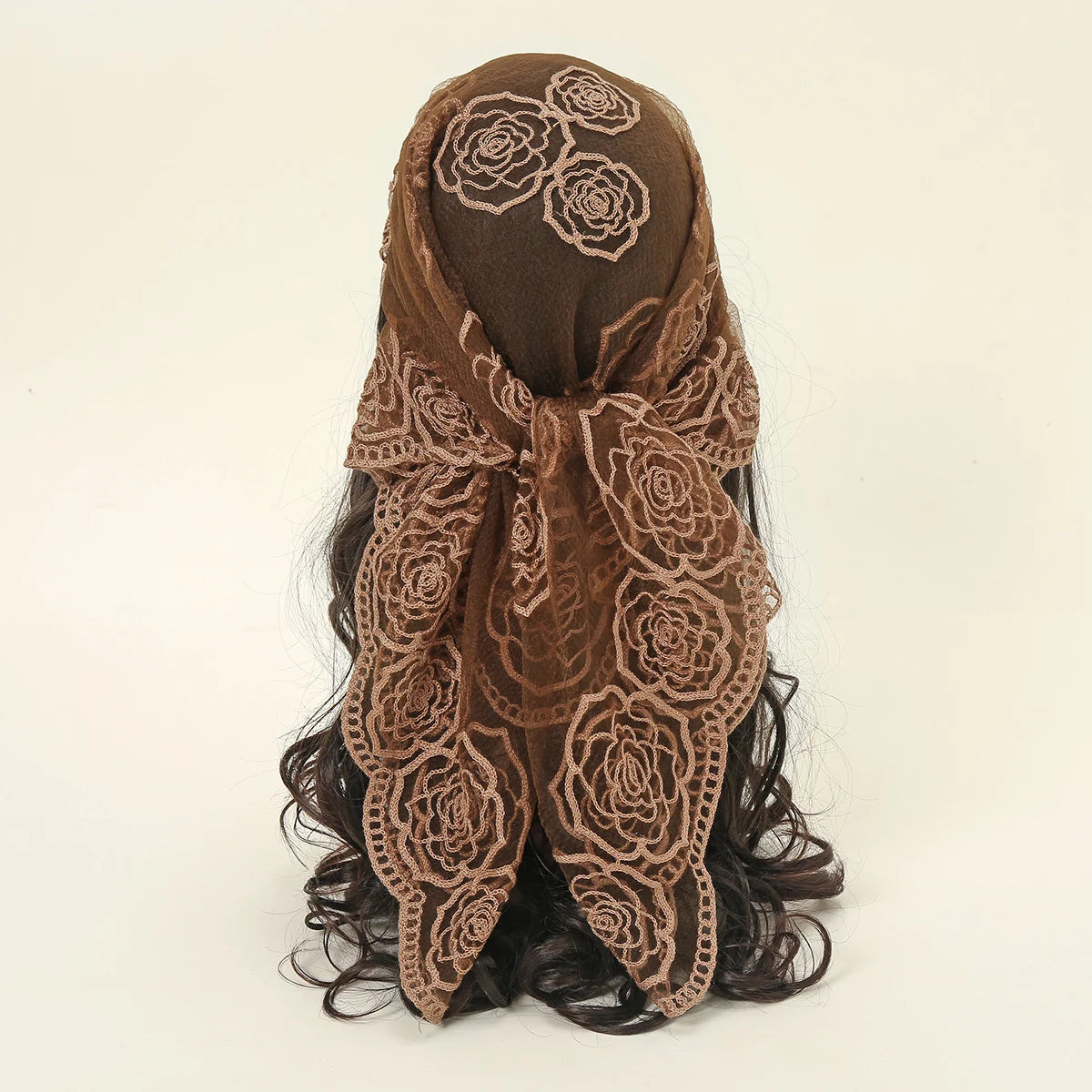 A dark brown floral embroidered lace bandana headscarf tied around a person's hair.