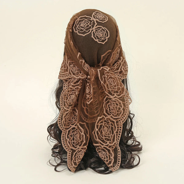 A dark brown floral embroidered lace bandana headscarf tied around a person's hair.