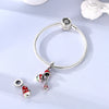 Sterling silver devil's eye charm bracelet with a silver bead and red and green charms
