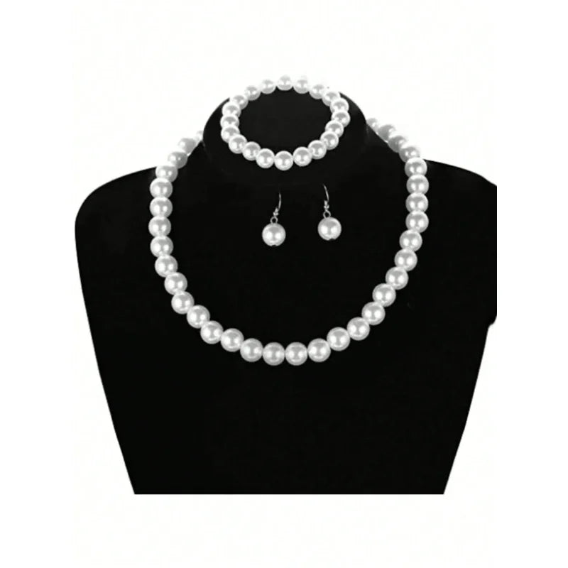 A necklace and matching earrings set of faux pearls displayed on a black jewelry stand.