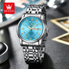 A silver stainless steel watch with a blue dial, Roman numerals, and luminous hands on a dark surface.