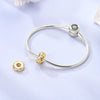 Sterling silver devil's eye charm bracelet with a textured band and a round charm.