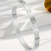 Silver stainless steel ring featuring four-leaf clover and nail motifs.