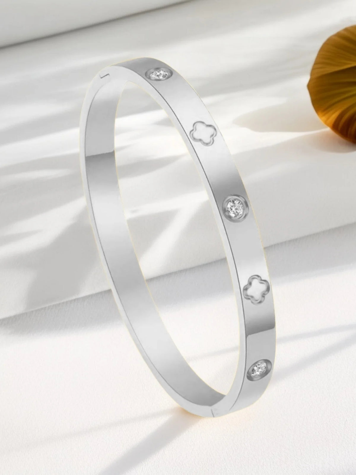 Silver stainless steel ring featuring four-leaf clover and nail motifs.