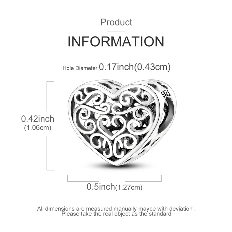 A sterling silver heart-shaped charm with intricate scrollwork and a small moon design.