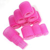 A stack of bright pink heatless hair curlers for DIY styling.