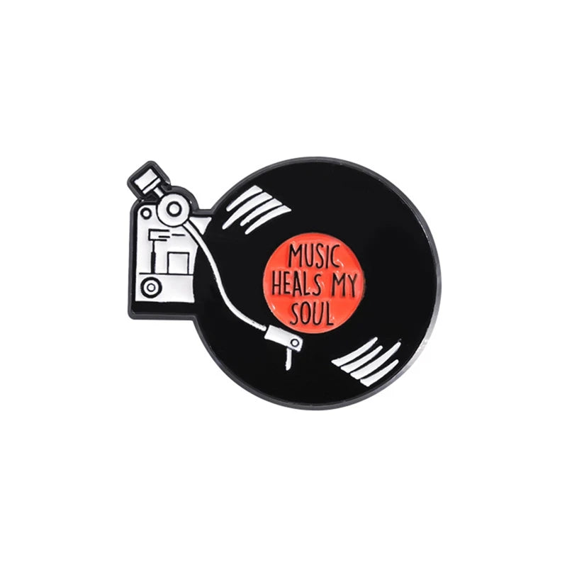 Broche émail noire avec une note de musique stylisée et le texte Music Heals My Soul
