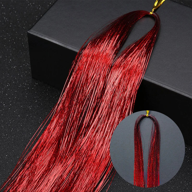 A bundle of long, vibrant red glitter hair extensions is displayed against a dark background.