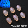 A collection of translucent pink acrylic beads and blue glow-in-the-dark beads are displayed on a black surface.