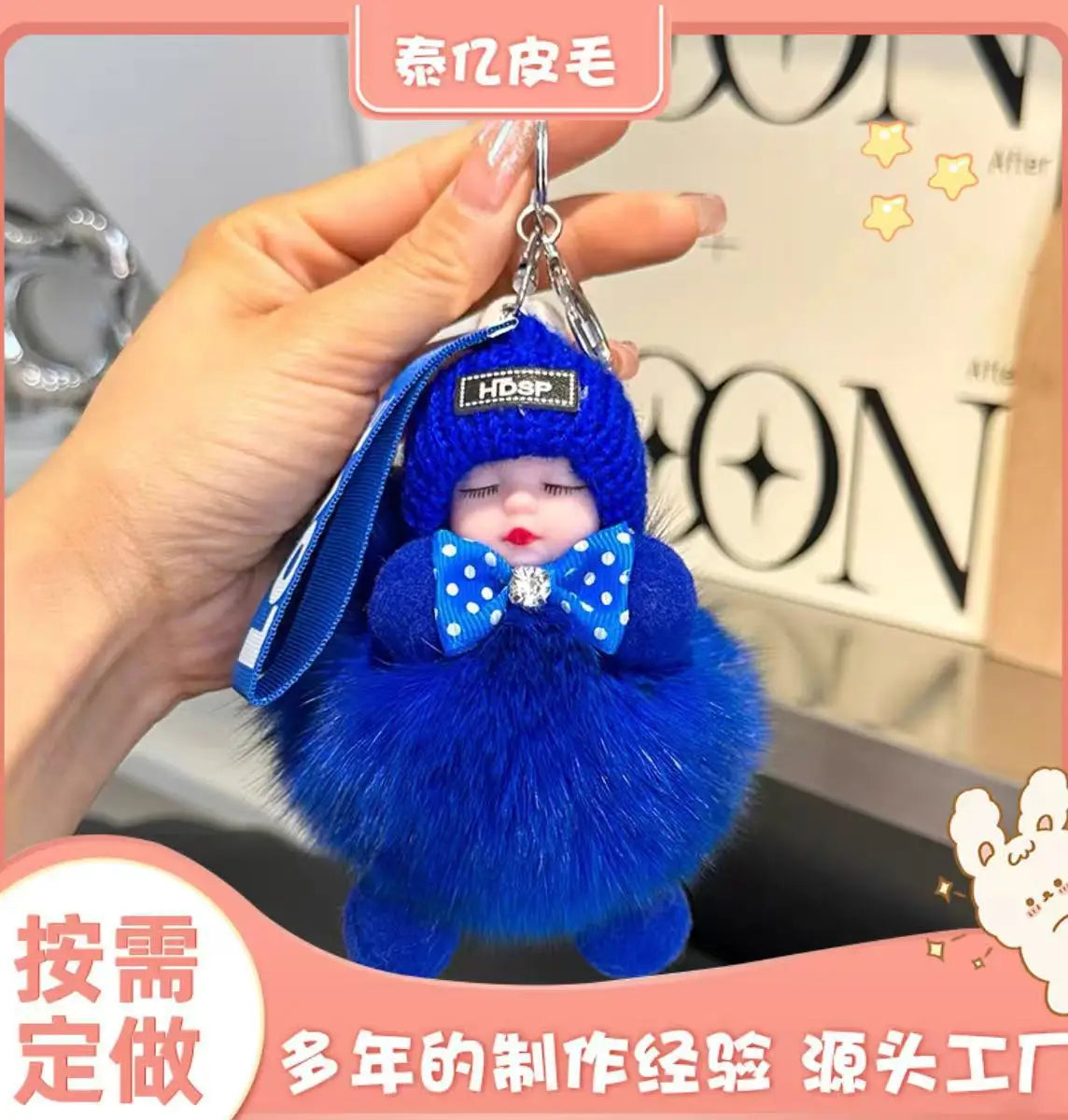 A bright blue fluffy cartoon plush doll with a blue hat and bow is being held by a hand.