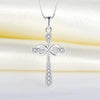 A silver cross pendant necklace with a detailed design and sparkling stones displayed on a white background.