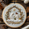 White embroidery depicting two figures in a natural wreath design on a light fabric background